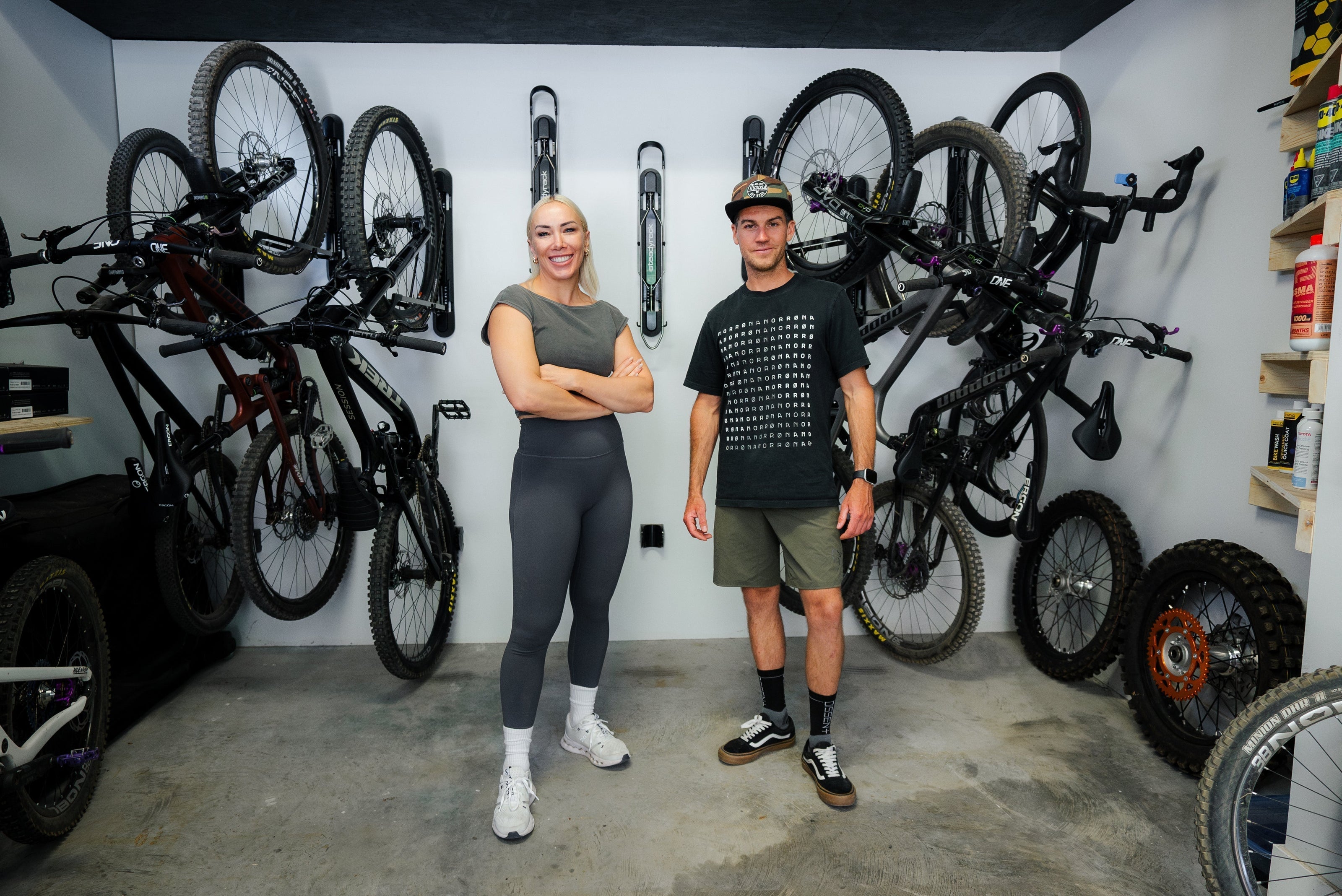 A female and male standing in front of a wall of Steadyrack bike racks with bike stored in them.