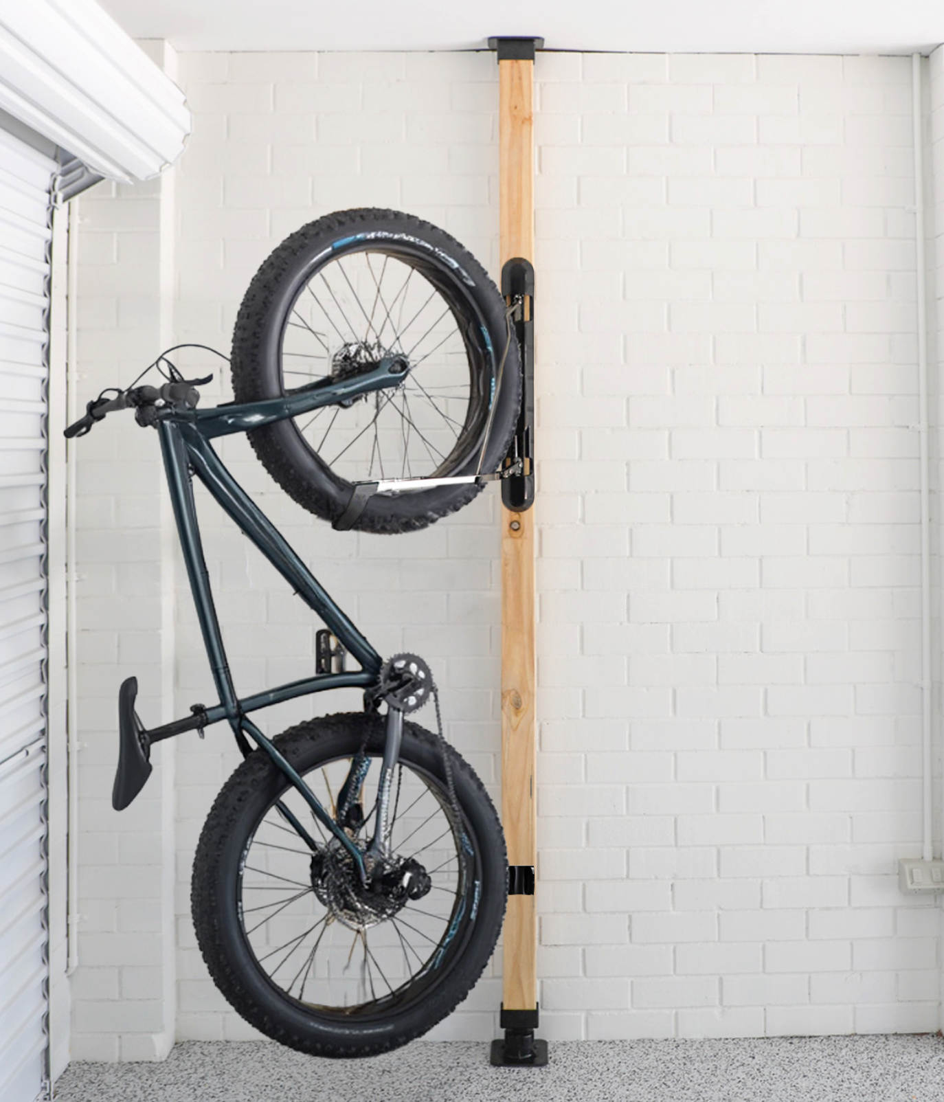 Bicycle installed on a wooden wall mount in a room with white tiled walls.